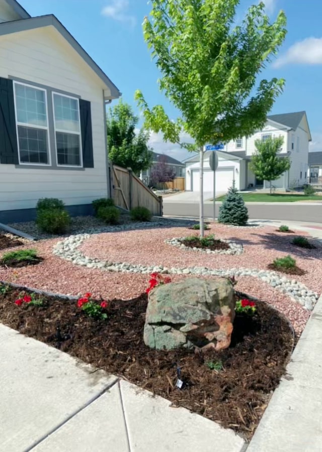A beautiful xeriscape depicting a sea of rocks, mulch, and border work, done by Minh.